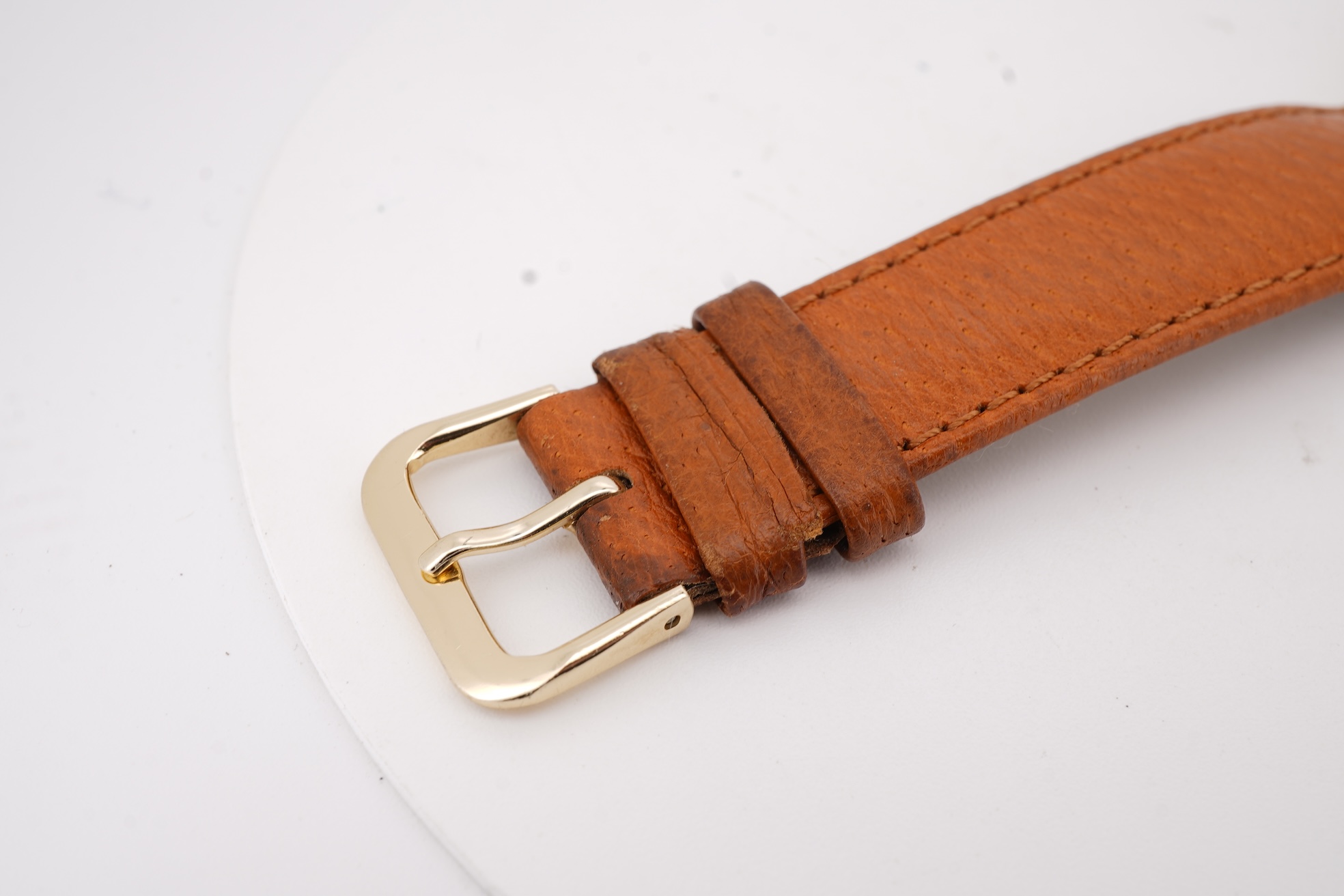 A gentleman's steel and gold plated Bulova Longchamp manual wind wrist watch, with baton numerals, case diameter 33mm, on a tanned leather strap.